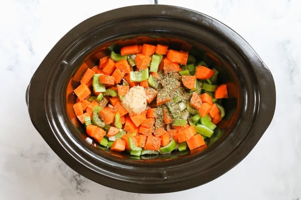 Chopped vegetables and garlic in a crockpot.