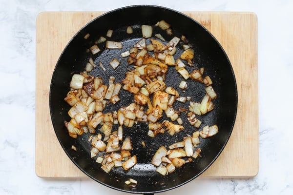 Onions being fried in a pan.