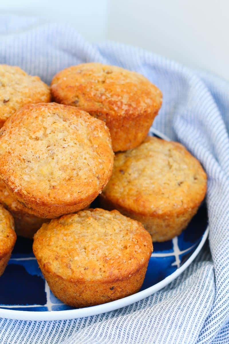 Ein Stapel Apfel-, Bananen-, Kokosnuss- und Dattel-Muffins auf einem blauen Teller.