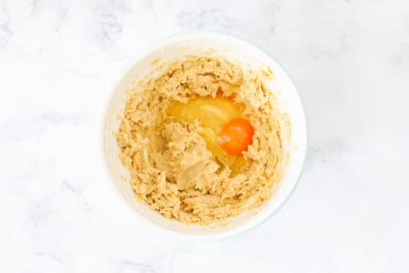 Egg being added to creamed sugar and butter.