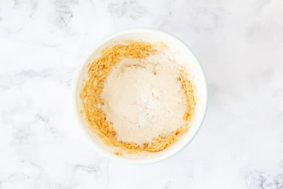 Plain flour and bi-card soda being added to cookie dough.