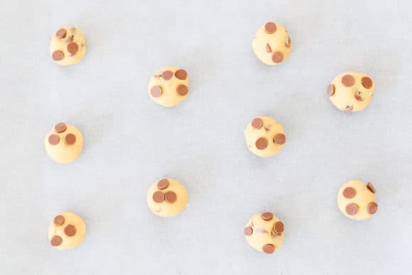 Chocolate chip cookie dough on a baking tray.