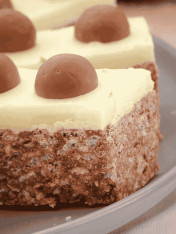 Pieces of white chocolate topped Malteser slice.