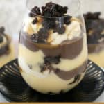 A glass jar filled with Baileys, custard, brownies and salted caramel in a trifle.