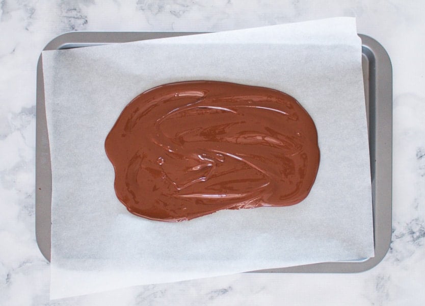 Melted chocolate on a baking paper lined tray.