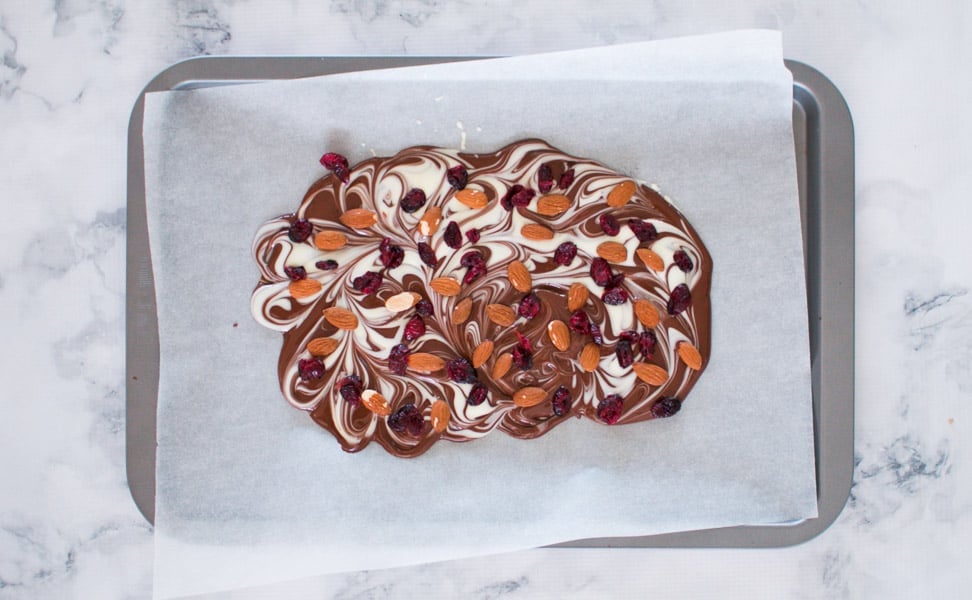 Dried cranberries and almonds on top of a chocolate bark.