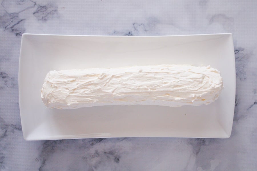 A no-bake dessert log smothered in whipped cream.