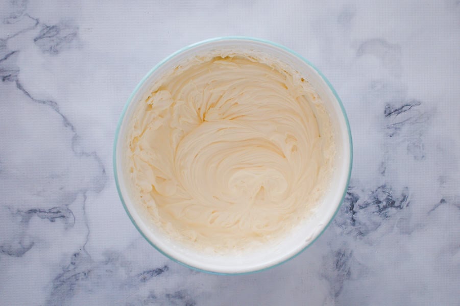 A bowl of whipped cream with soft peaks.