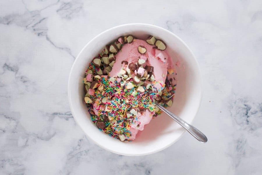 Strawberry ice-cream in a bowl with Clinkers and sprinkles.