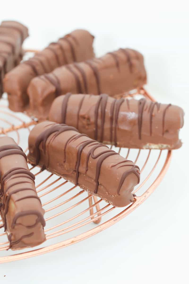 Milk chocolate bars drizzles with dark chocolate on a copper cake wire rack.