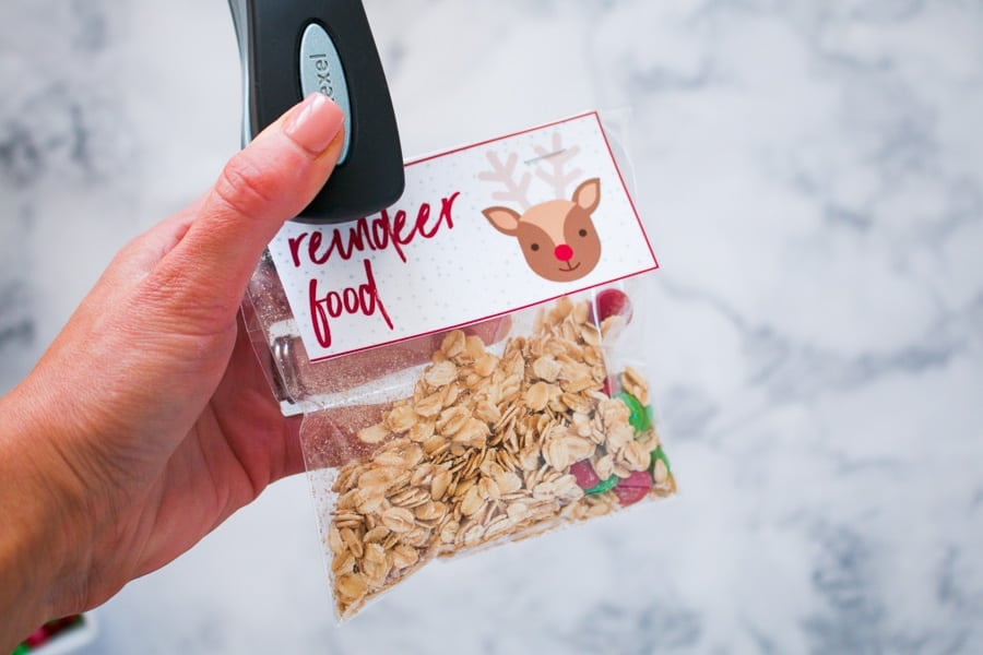 A stapler sticking a label with Reindeer Food on it onto a bag of oats and M&Ms.
