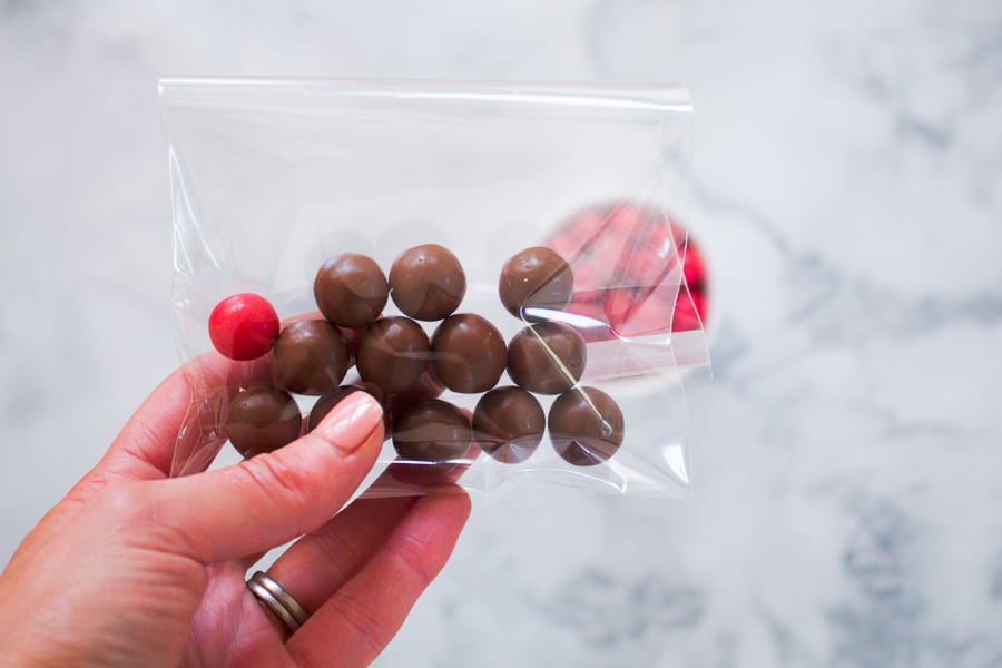 Maltesers and a red Jaffa in a clear bag.