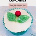 A cupcake iced with buttercream, and decorated with sweets to look like holly.