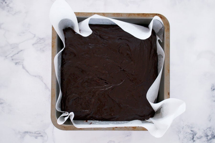 Brownie batter in a square baking tin.
