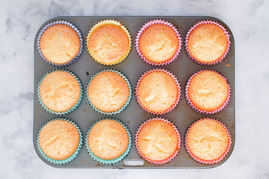 Lightly golden cupcakes in a muffin tray.
