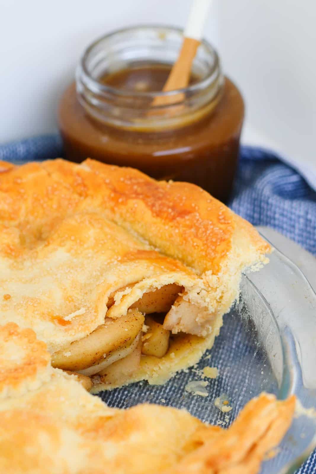 An apple pie with flaky pastry and apple filling in a baking dish.