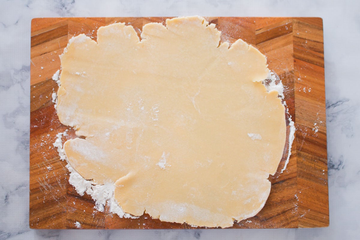 Shortcrust pastry rolled out on a chopping board.