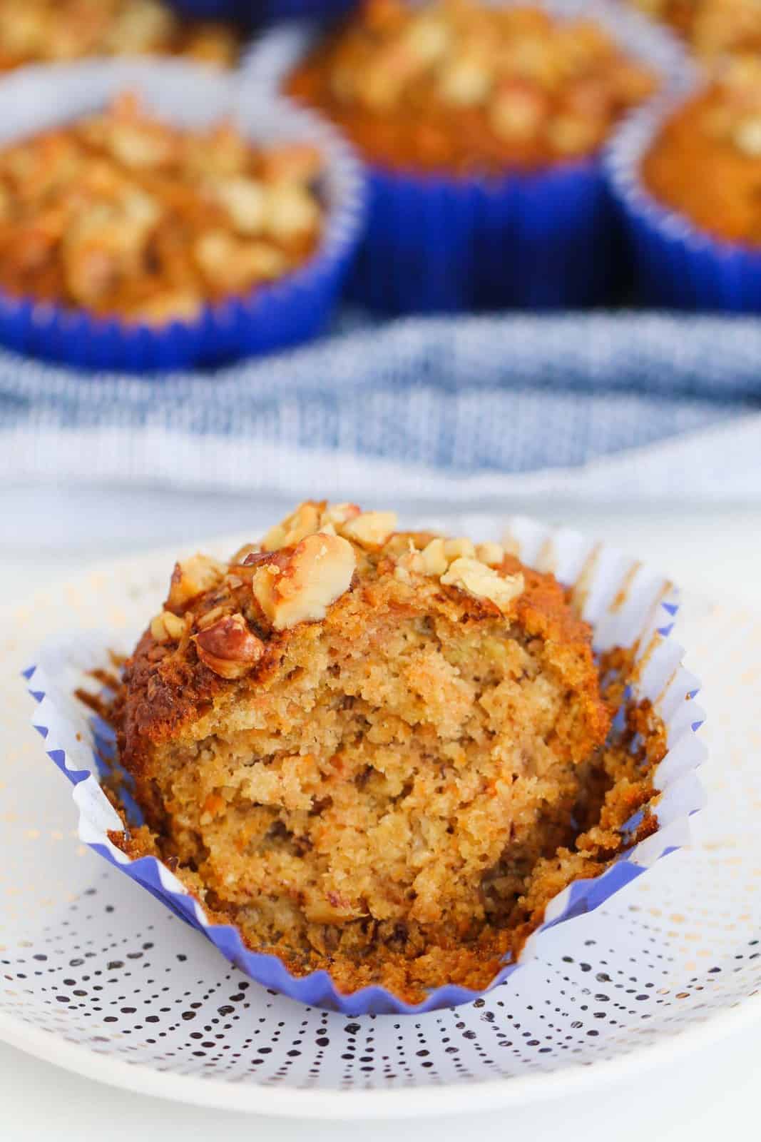 A moist muffin made with carrot, apple and banana split open on a plate.