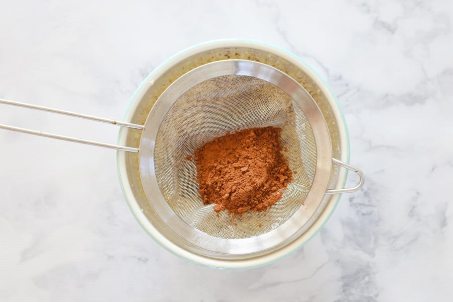 Cocoa powder being sifted into a bowl.