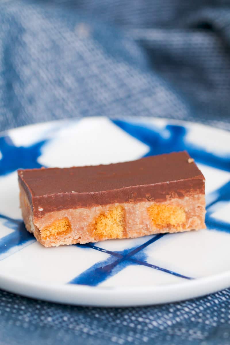 A piece of chocolate honeycomb slice on a blue and white plate.