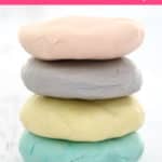 4 discs of homemade playdough in pastel colours.