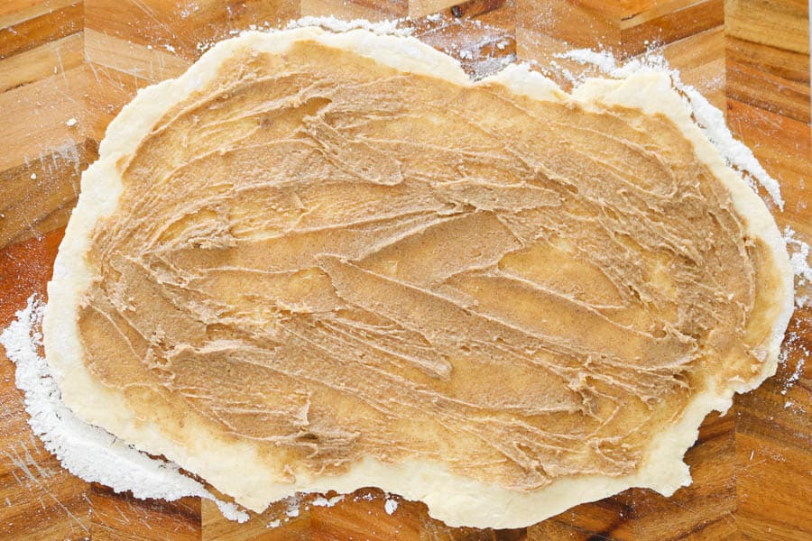 Homemade cinnamon and brown sugar butter spread over dough.