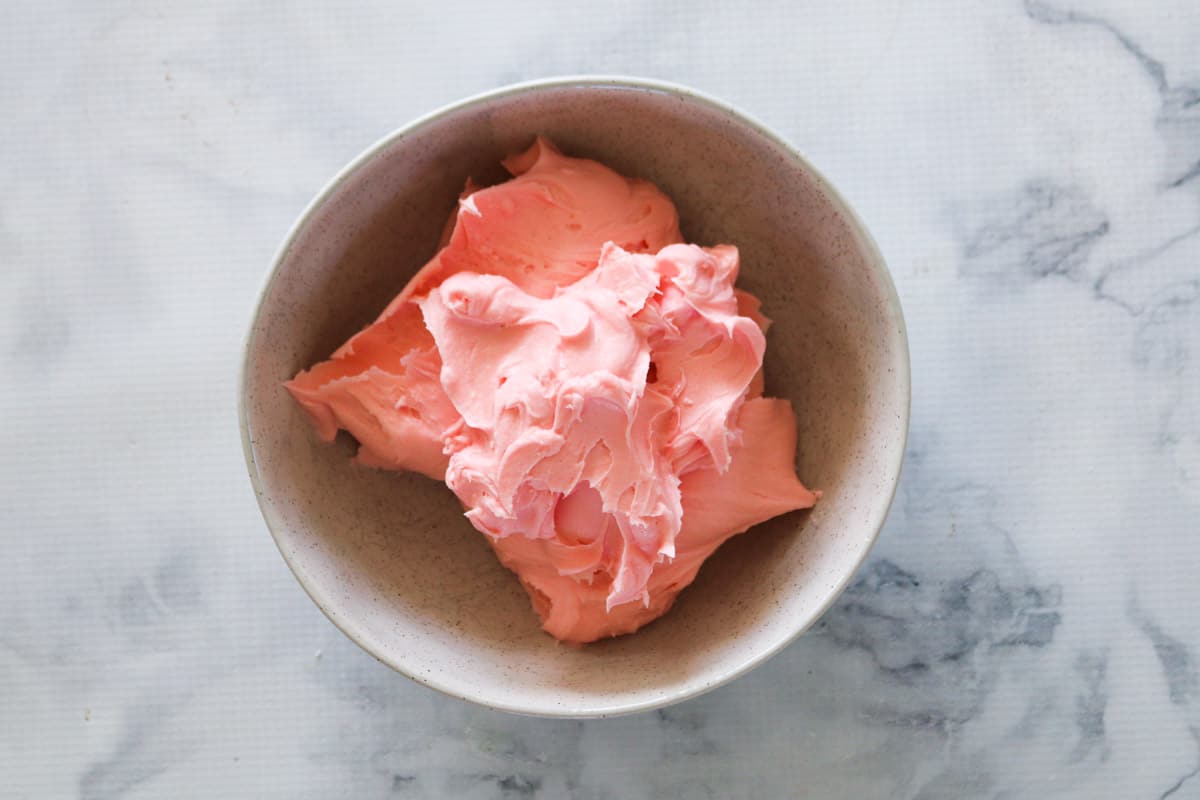 Pink buttercream icing in a bowl.