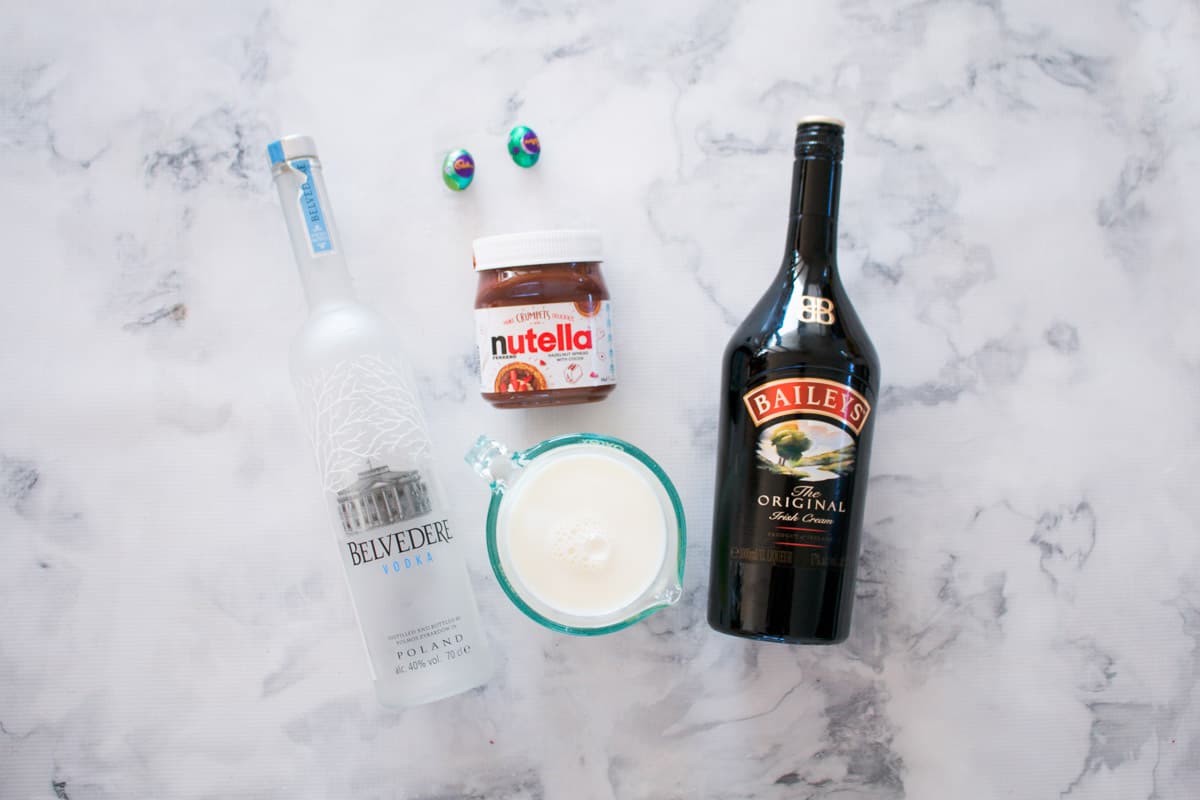 The ingredients for an Easter cocktail, Baileys, vodka, milk, nutella and Easter eggs.