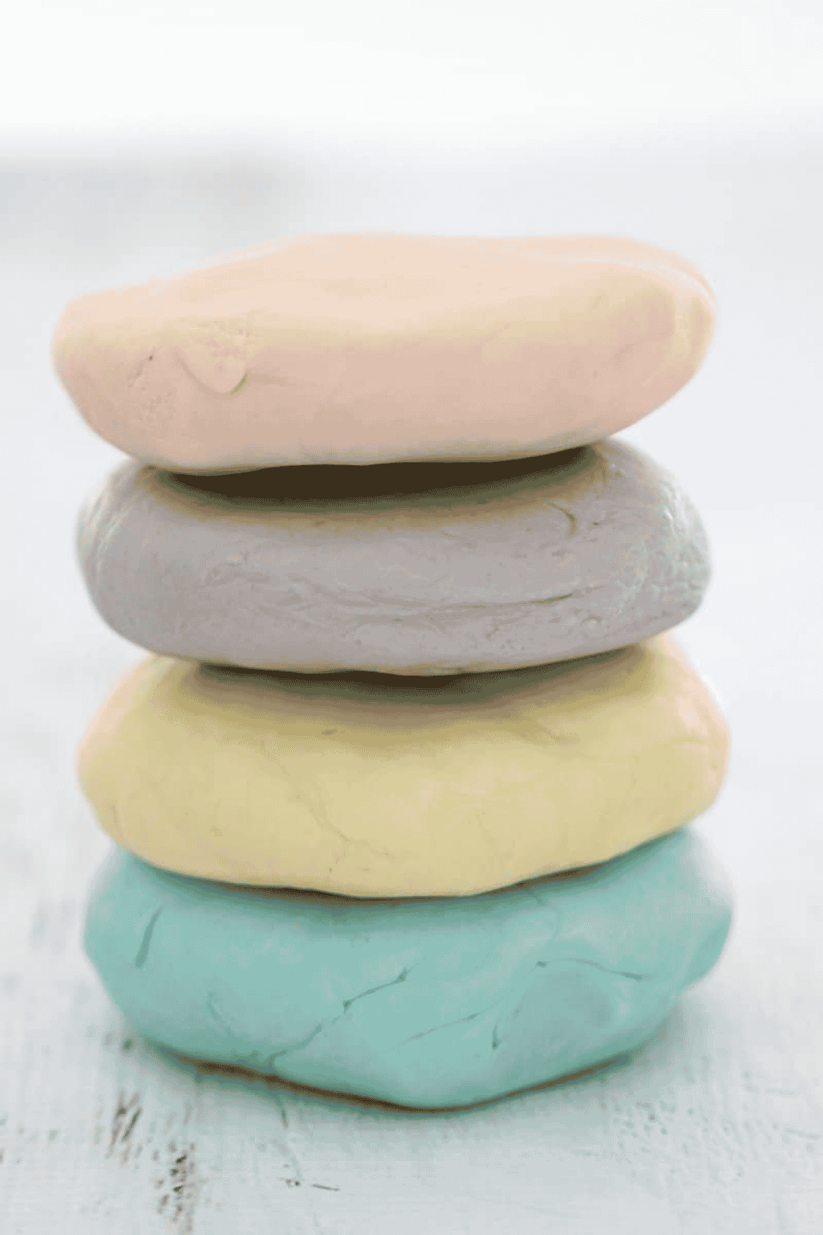 Discs of colourful playdough on a bench.