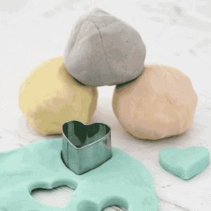 Balls of homemade playdough on a bench.