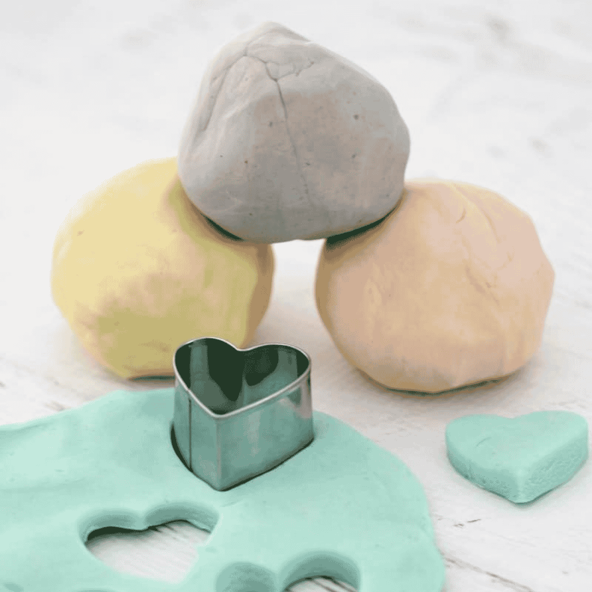 Balls of homemade playdough on a bench.