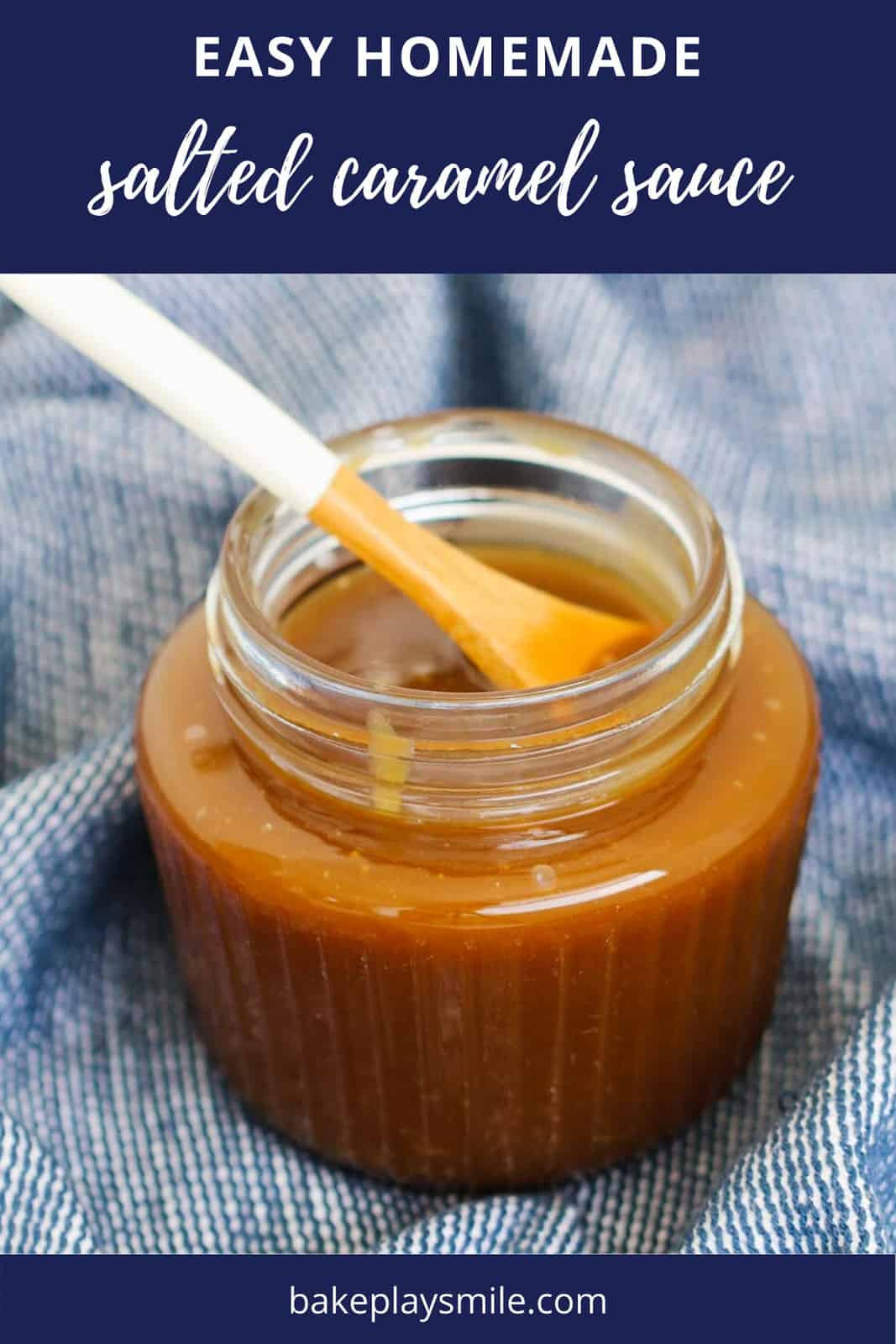 Homemade caramel sauce in a glass jar with a small wooden spoon dipped in.
