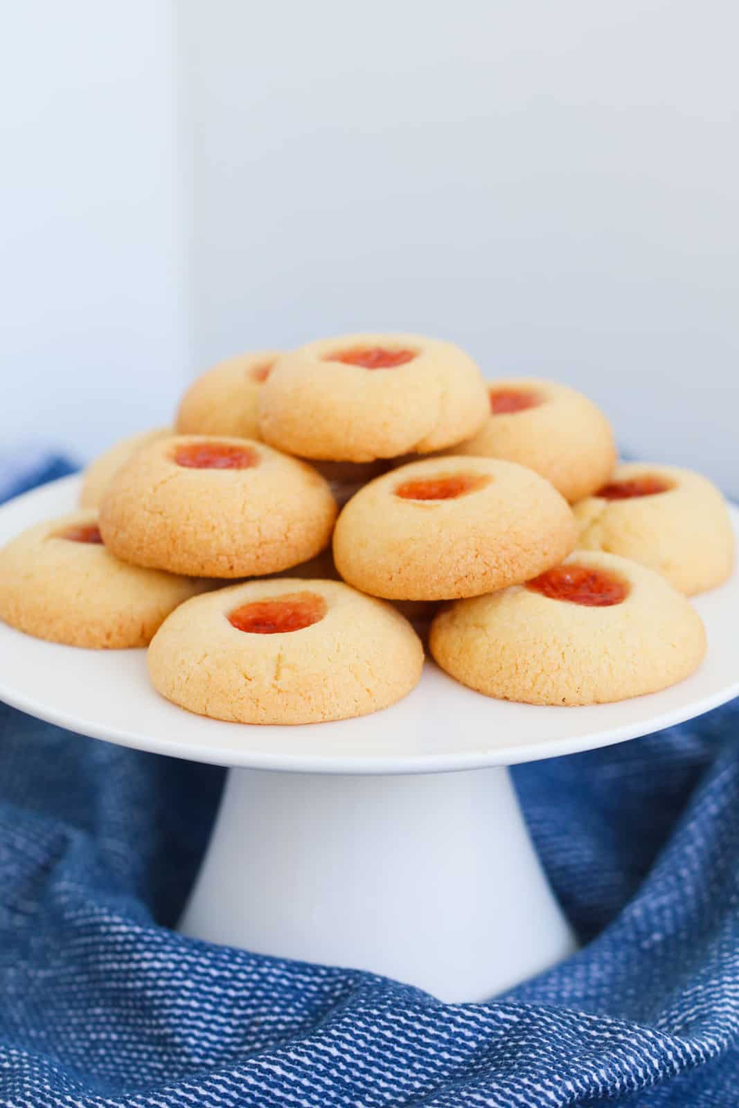 A plate of vanilla cookies with a filling of raspberry jam in the center.