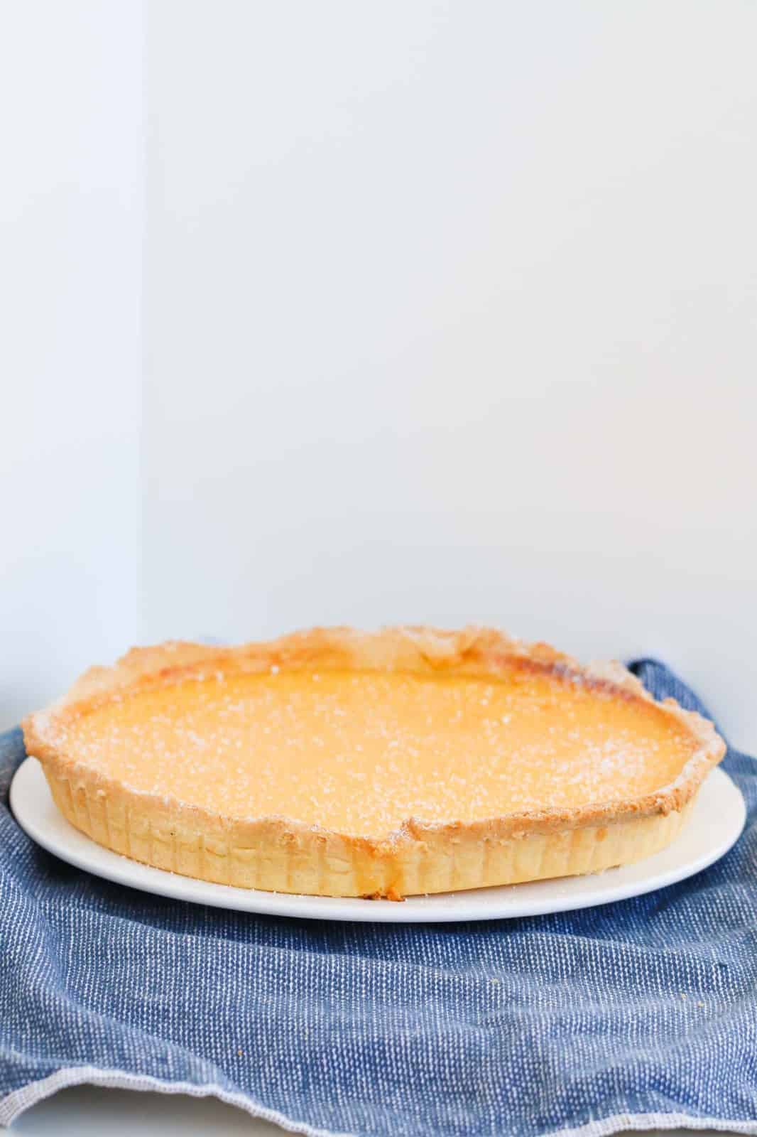 A round dessert tart with pastry and lemon filling.