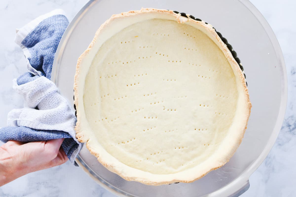 A par-baked sweet shortcrust pastry base with fork prints in the base.