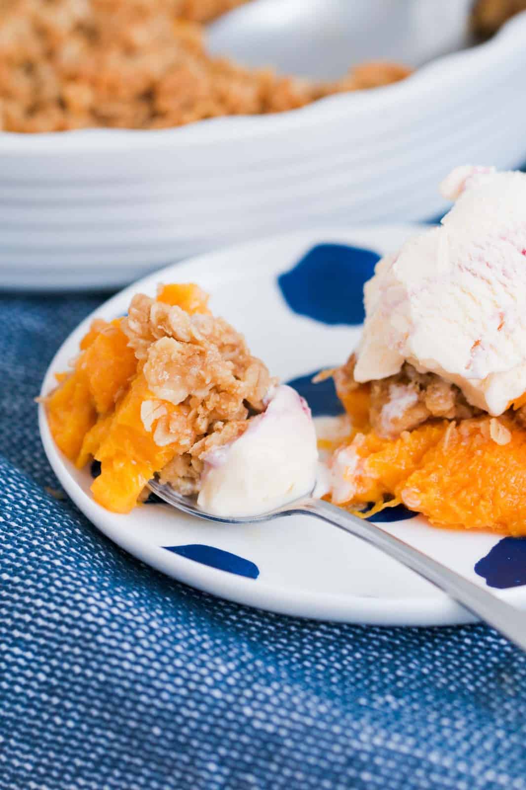 A spoonful of peach and rolled oat streusel on a plate.
