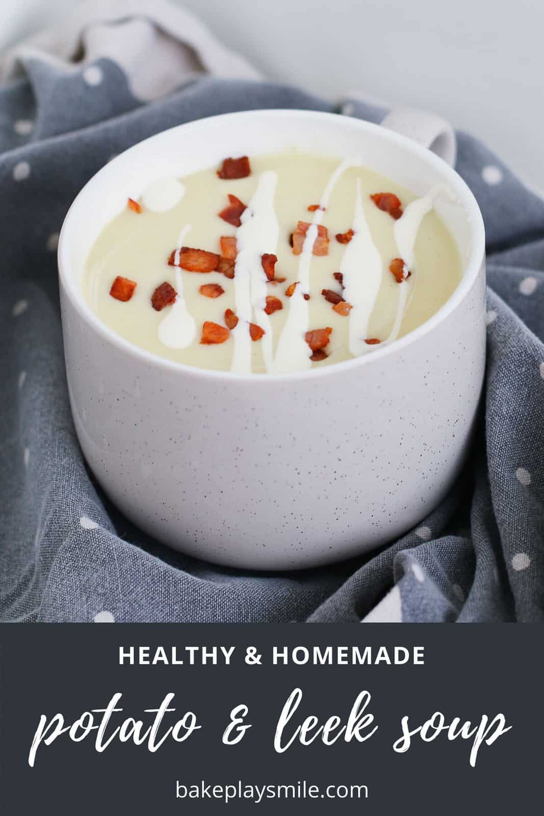 A mug of creamy potato soup with leeks, bacon and cream.