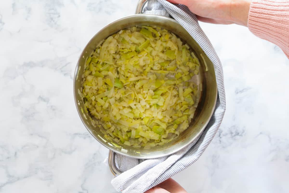 Sauteed onions and leeks in a saucepan.