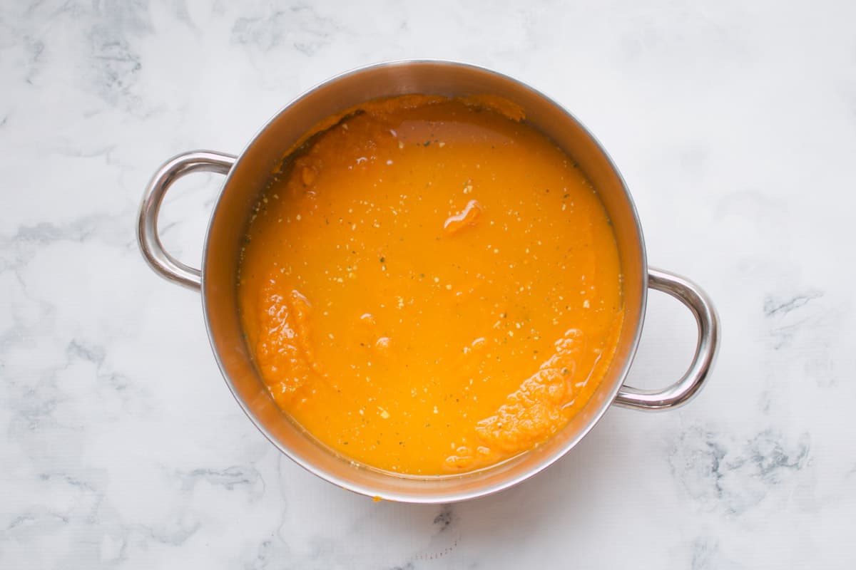 Orange vegetable soup in a saucepan.