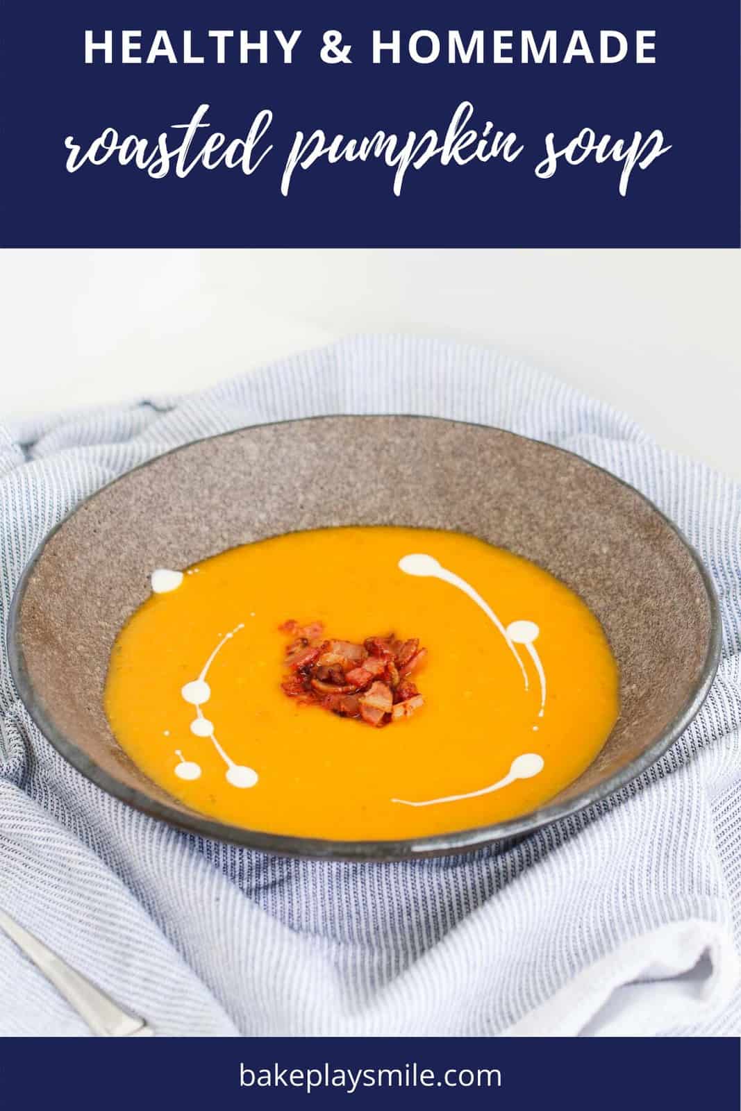 A bowl of pumpkin soup swirled with cream and topped with crispy bacon.