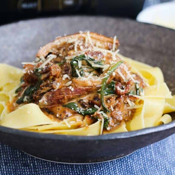 Creamy Tuscan slow cooker chicken with sun-dried tomatoes and spinach.
