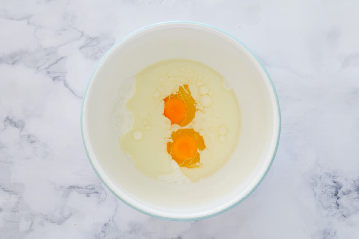 Eggs, oil and buttermilk in a bowl.