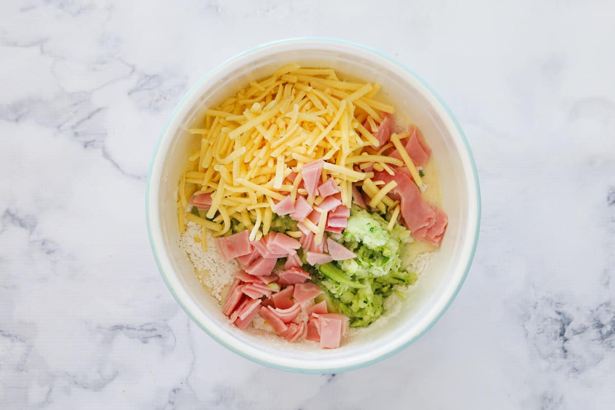 Cheese, ham and zucchini in a bowl.