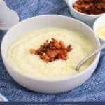 A bowl of creamy white soup with bacon and parmesan.