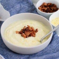 A bowl of creamy white soup with bacon and parmesan.