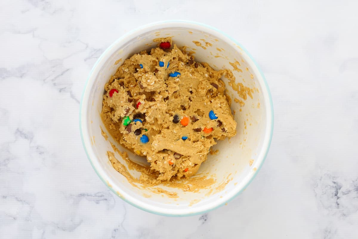 M&M cookie dough in a white mixing bowl.