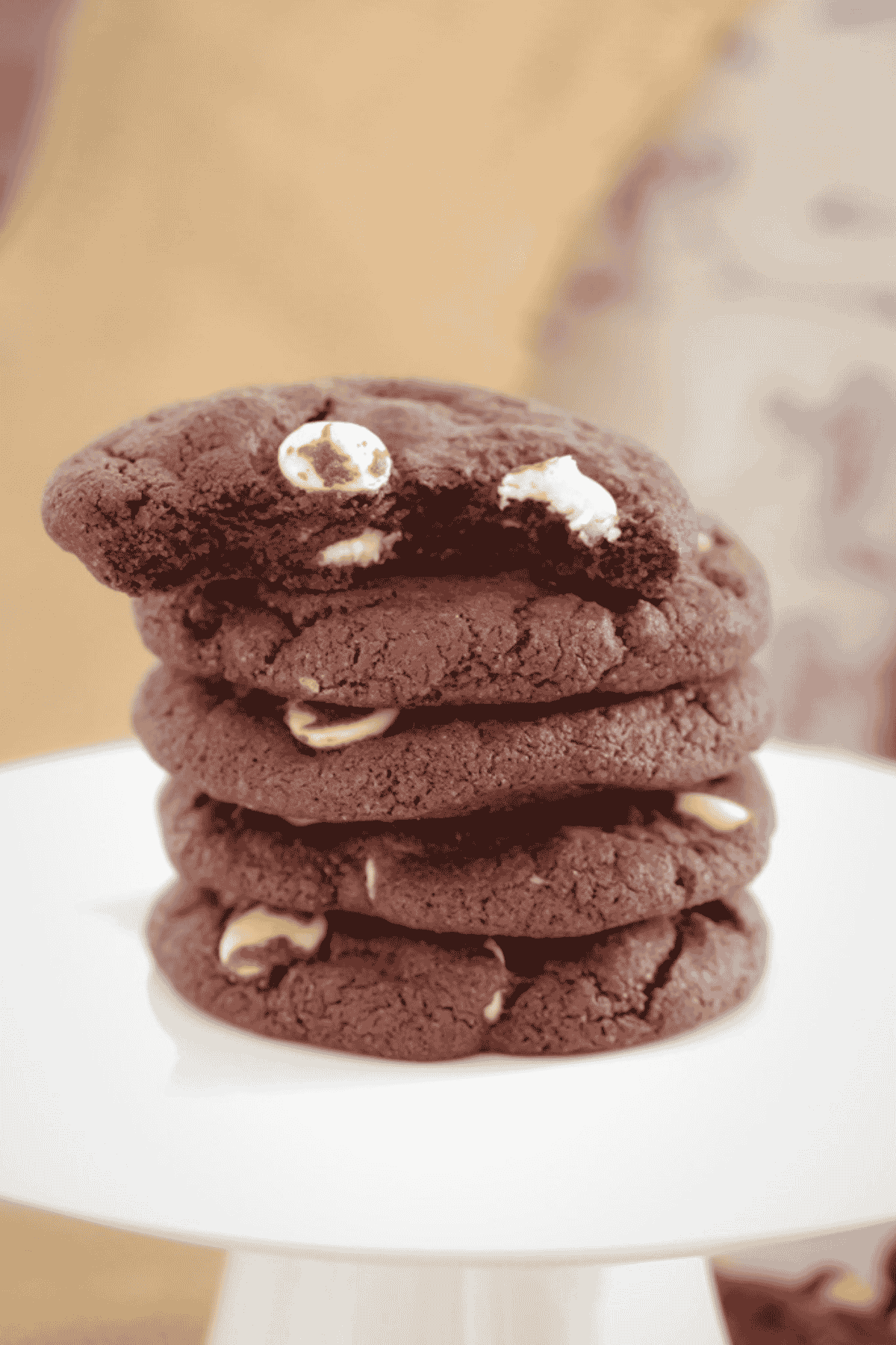 Dark chocolate chip cookies on a white plate.
