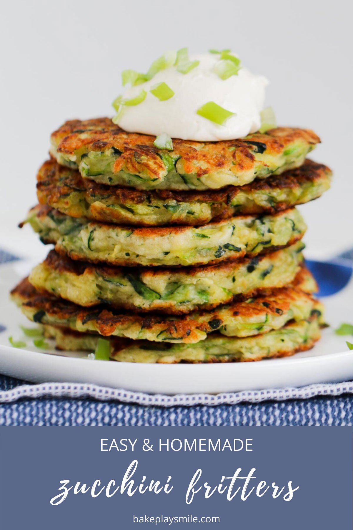 Six vegetable fritters in a stack with sour cream on top. 