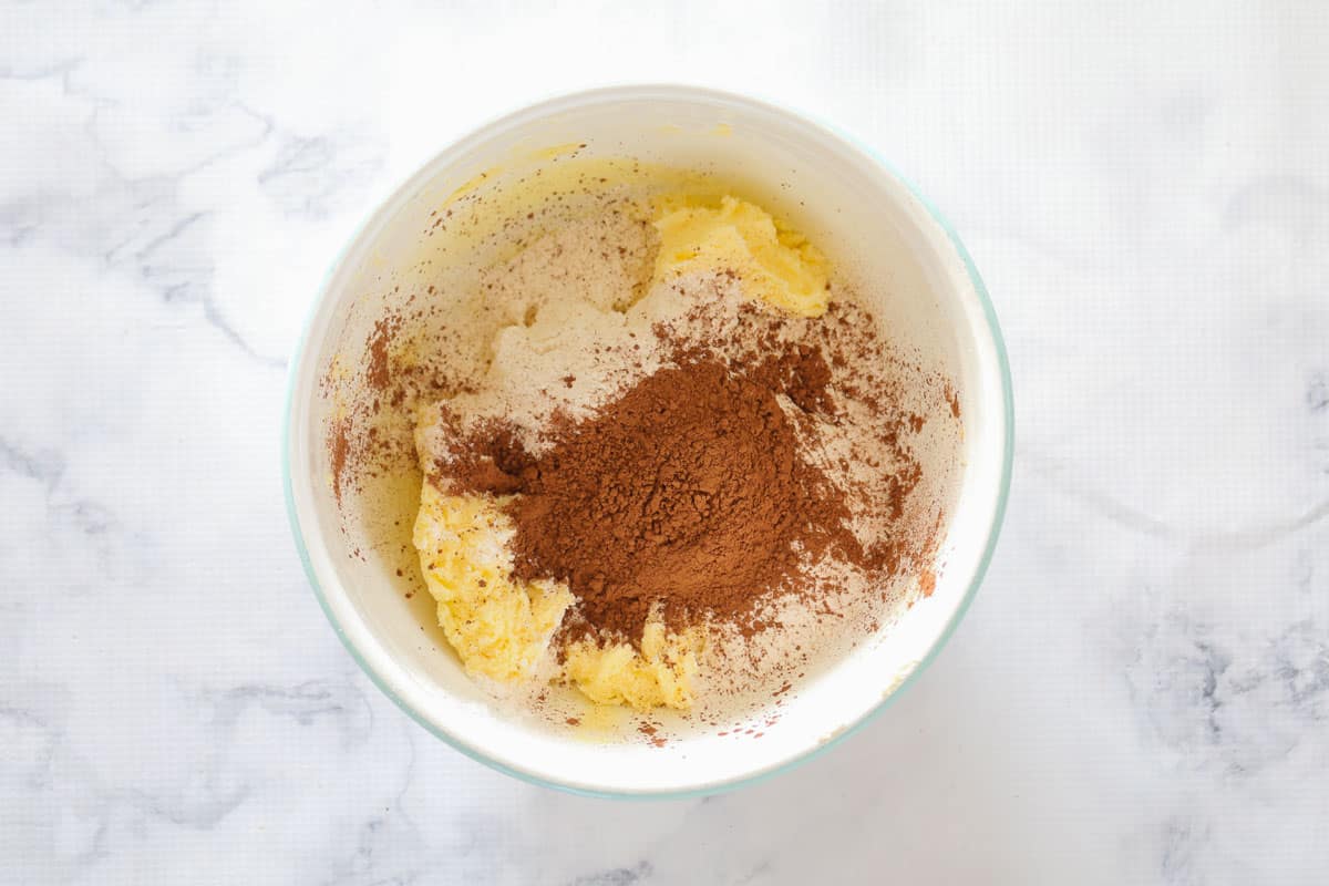 Butter, flour and cocoa powder in a white mixing bowl.