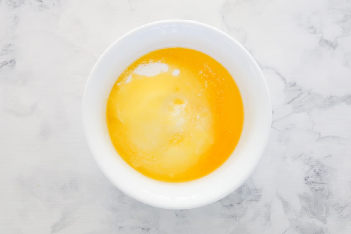 Melted butter and condensed milk in a white bowl.